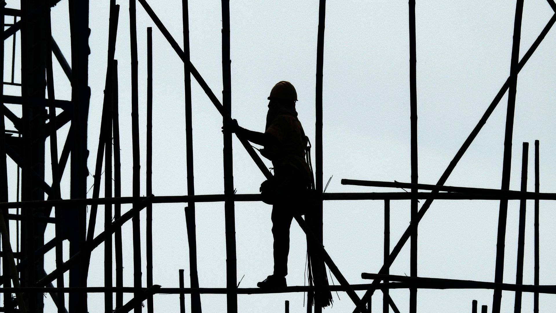 Een bouwvakker beklimt een ladder.